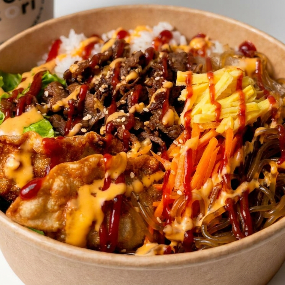 Korean-inspired rice bowl topped with beef, dumplings, glass noodles, vegetables, sesame seeds, and spicy sauces.